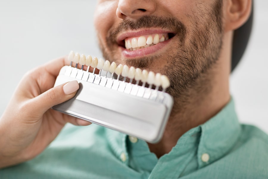 A man happily holds a toothbrush, ready to brush his teeth.