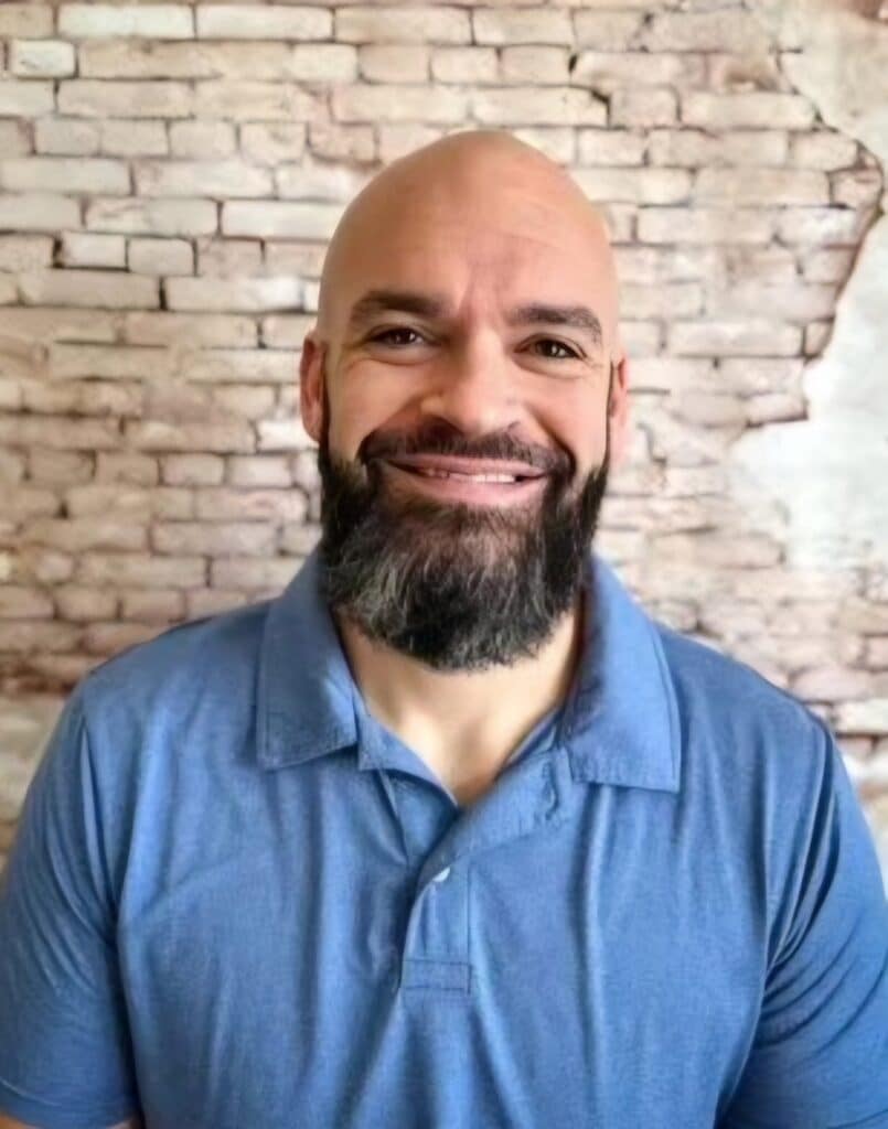 a man with a mustache in a blue poloshirt