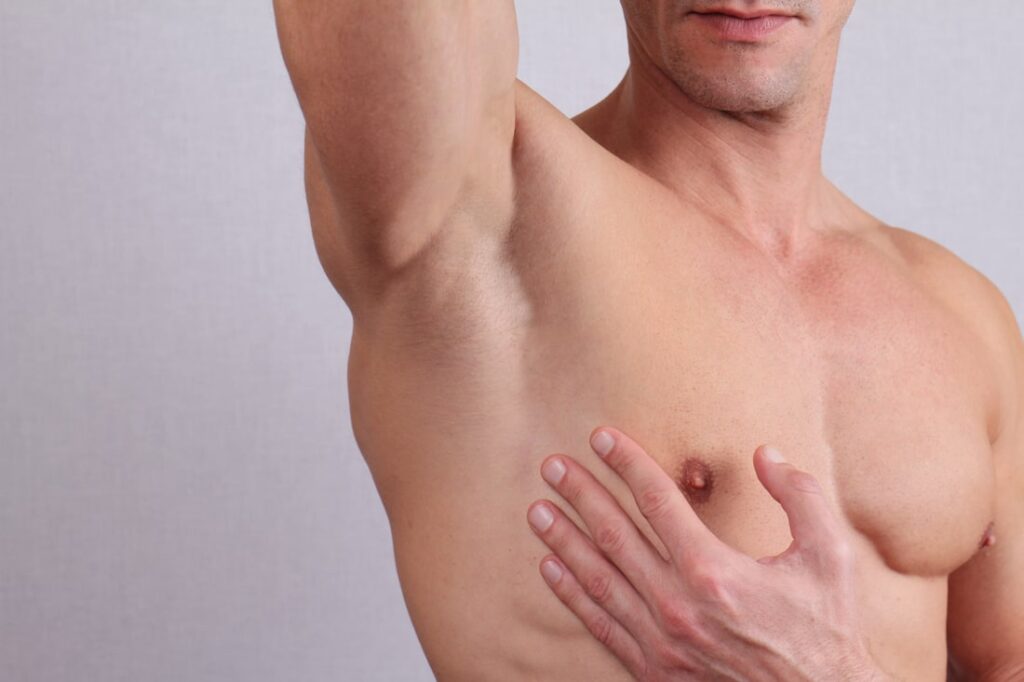 A man gently touches his chest, symbolizing care and healing in the context of ivee restorative care.