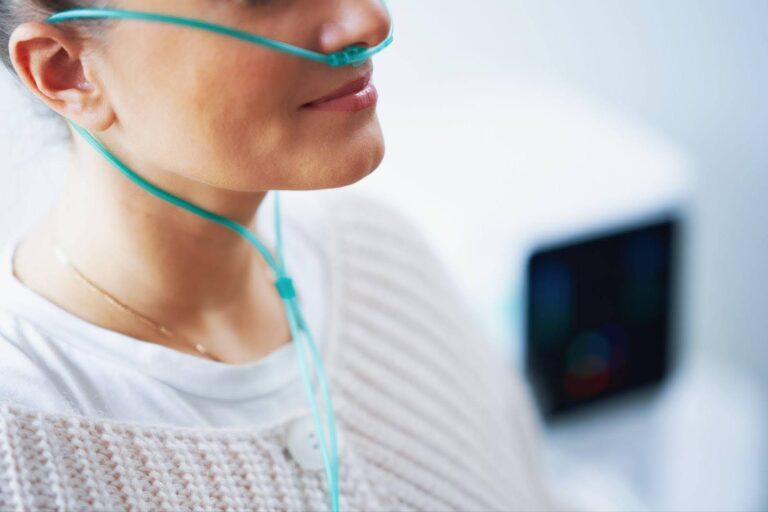 A woman receiving oxygen therapy through a nasal cannula, highlighting the importance of maintaining healthy oxygen levels.